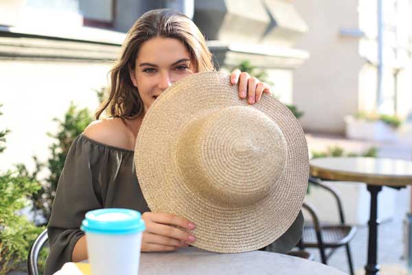 Pretty Girl Hiding Her Face Behind A Straw Hat